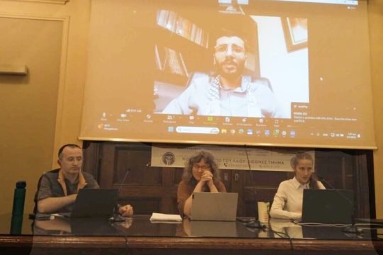 Από αριστερά: Γκιουνάι Νταγκ, Ευγενία Κουνιάκη, Κωνσταντίνα Καρτσιώτη (μέλος του Λαϊκού Μετώπου και συντονίστρια). Στη γιγαντοοθόνη ο Παλαιστίνιος δικηγόρος Φουάντ Μπακέρ